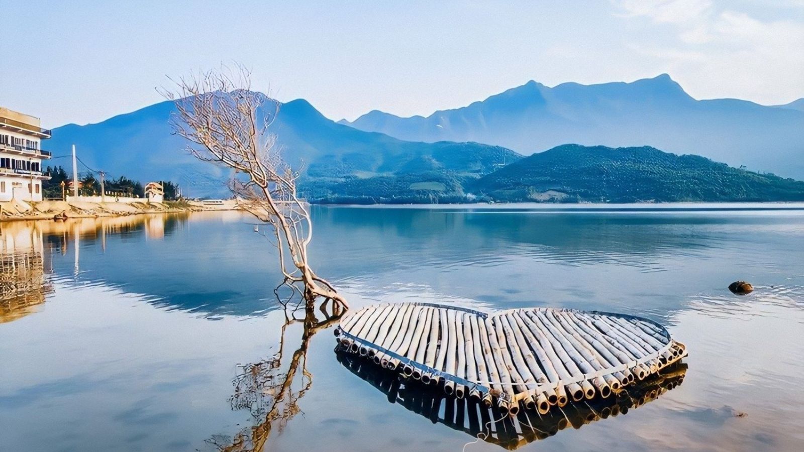 Veduta da lontano della laguna di Lap An con il suo poetico scenario tra montagne e acque tranquille.