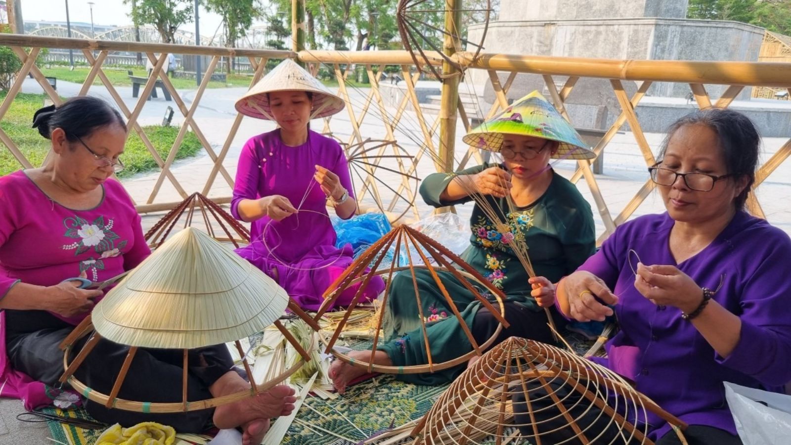 Cảnh làm việc tại làng nghề truyền thống với các nghệ nhân đang tạo ra sản phẩm thủ công.