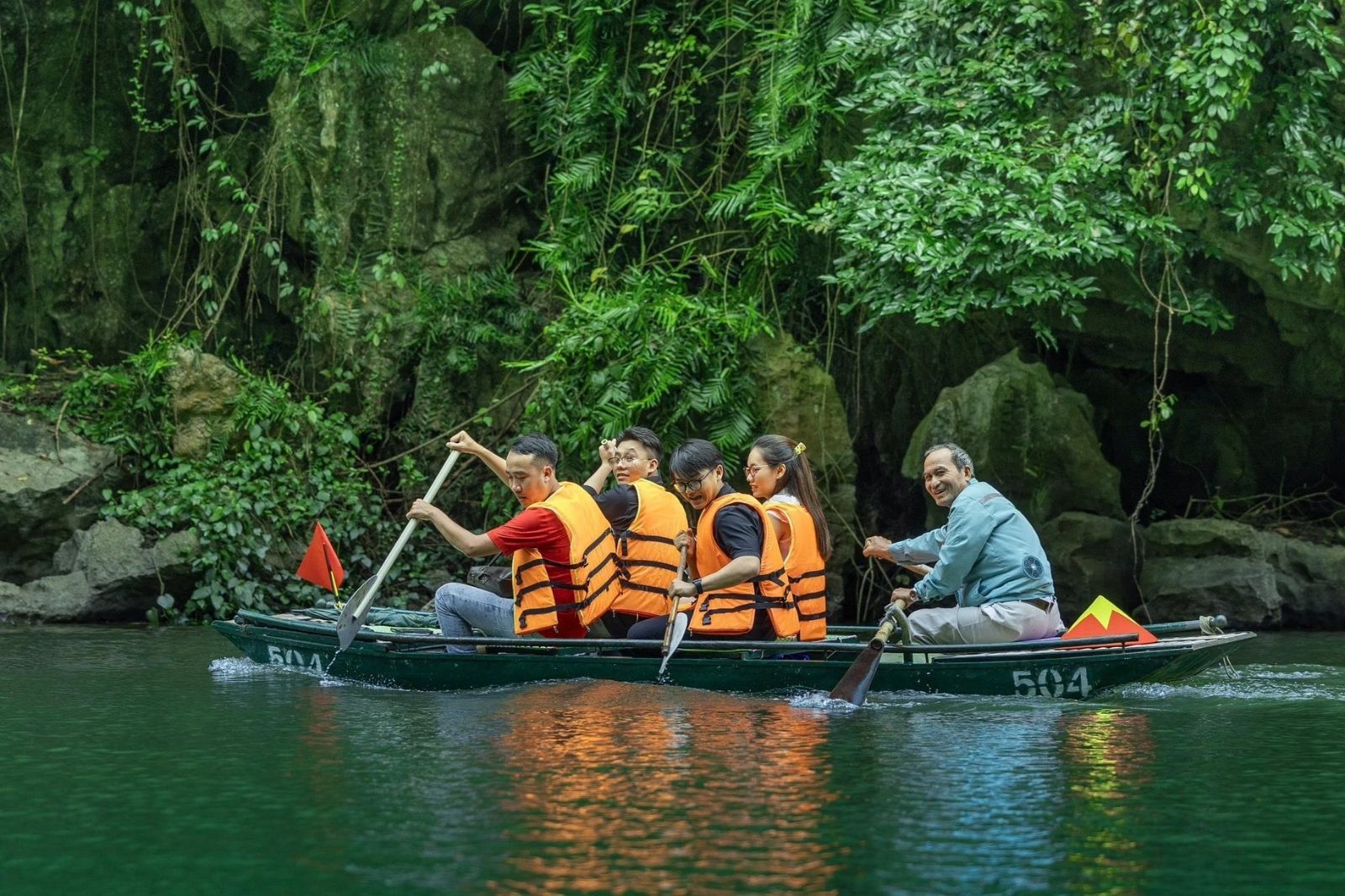 Du khách ngồi thuyền để đến Hang Nấu Rượu
