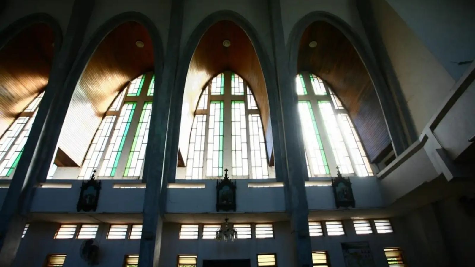 Die Bogenfenster der Kathedrale Phu Cam sind mit blauen Glaspaneelen verziert.