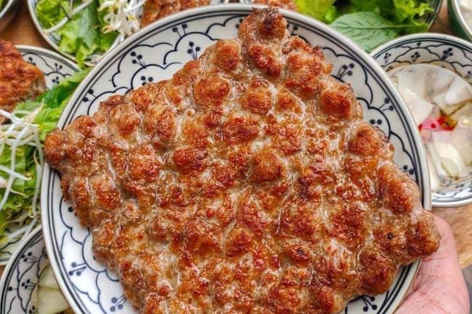 Phần chả được ép chặt tay trong vỉ nướng