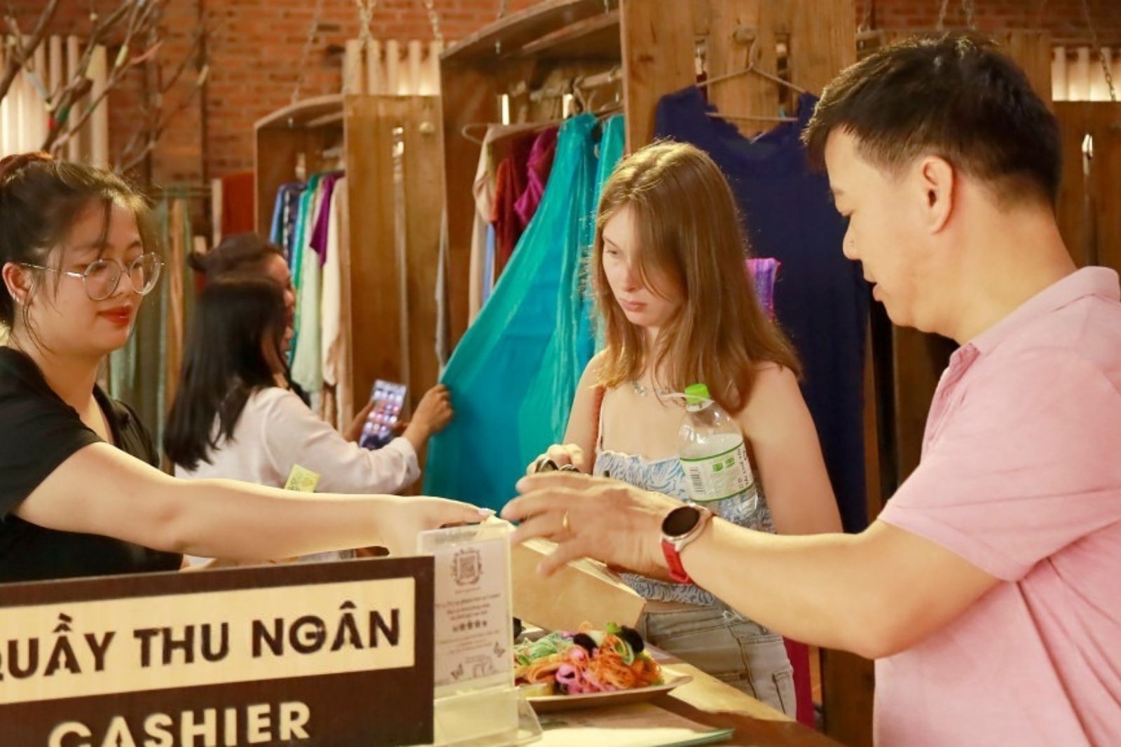 Du khách tham quan và mua sản phẩm thêu ren