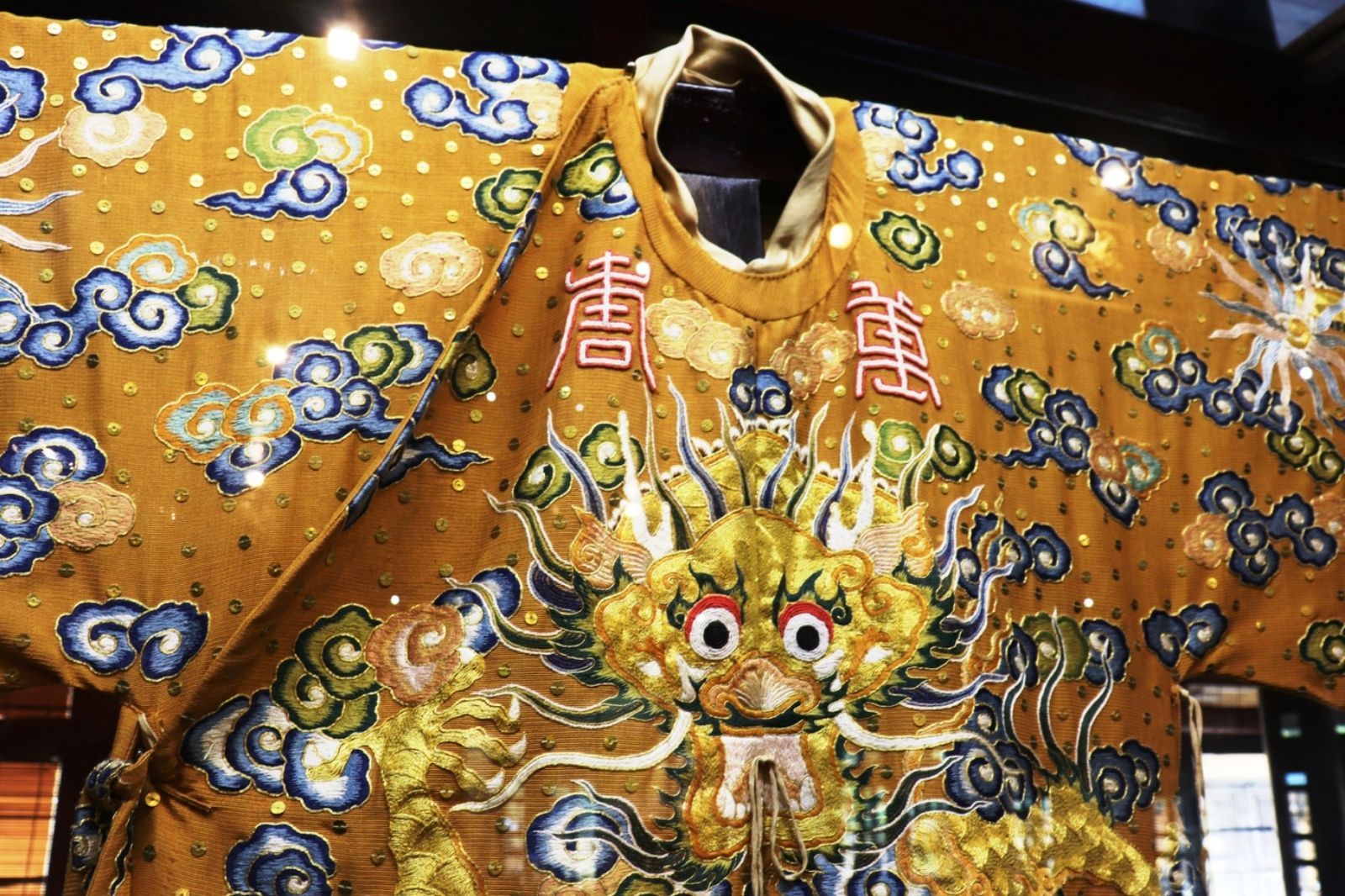 Trang phục được thêu dày đặc các hoa văn rồng mây và sóng nước 